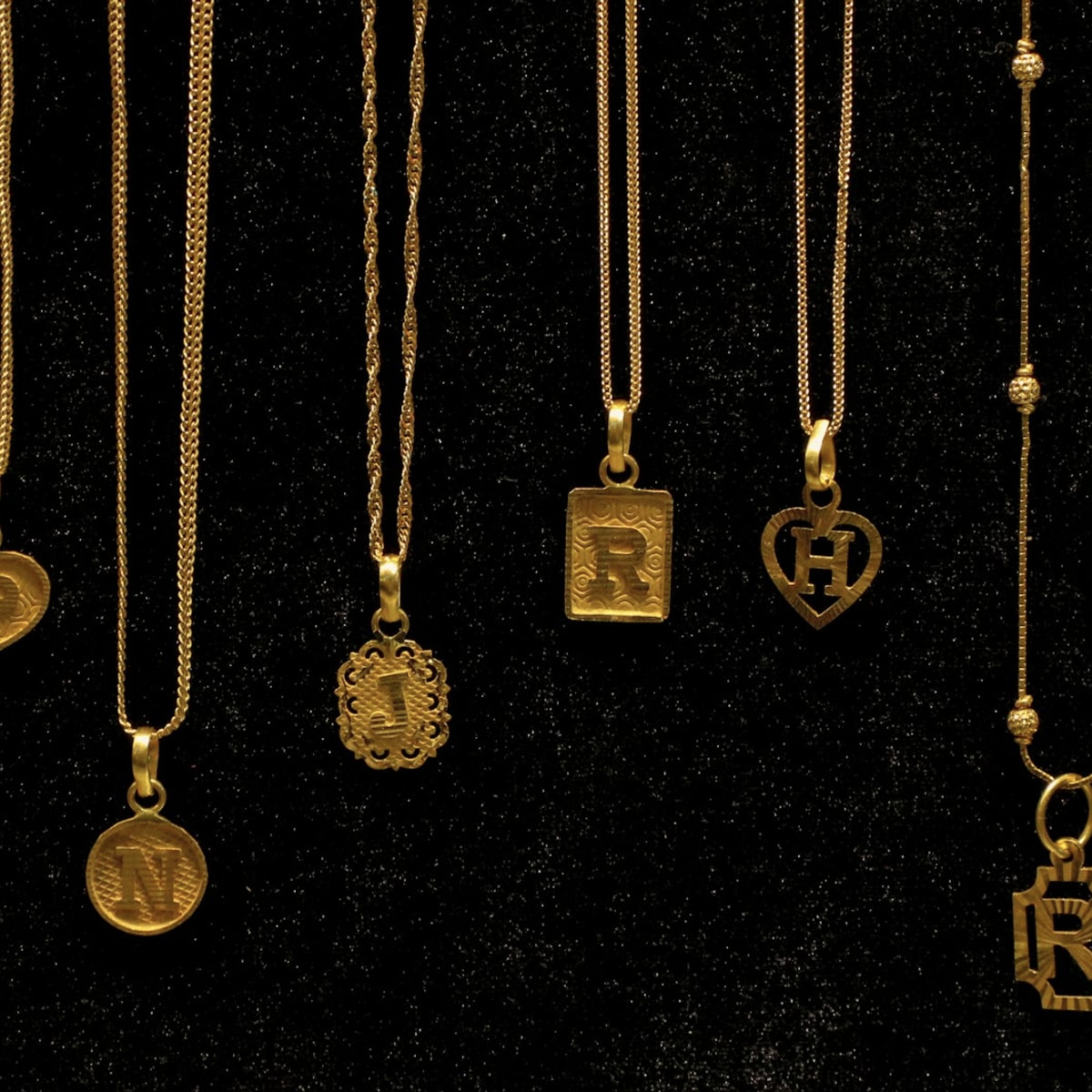 Verschillende gouden initiaalhangers naast elkaar