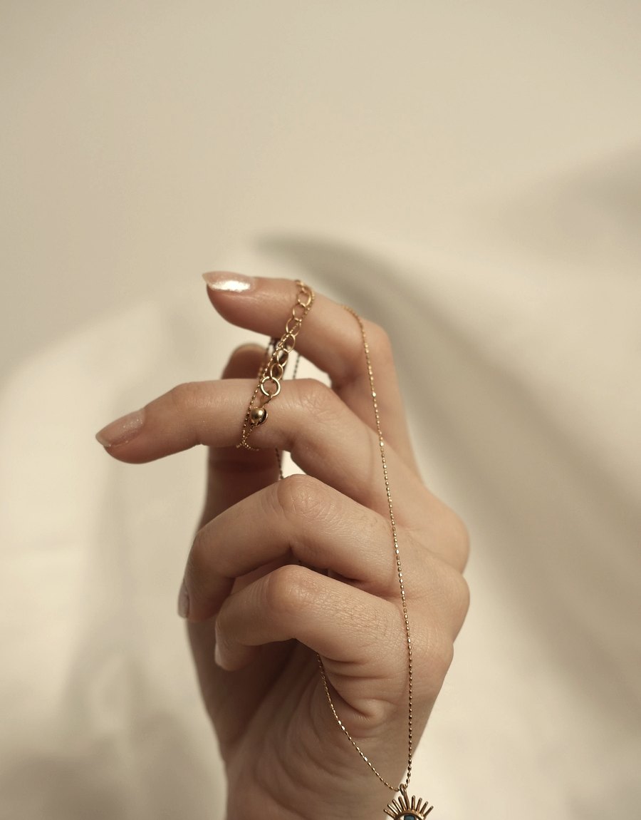 Hand met fijne gouden ketting