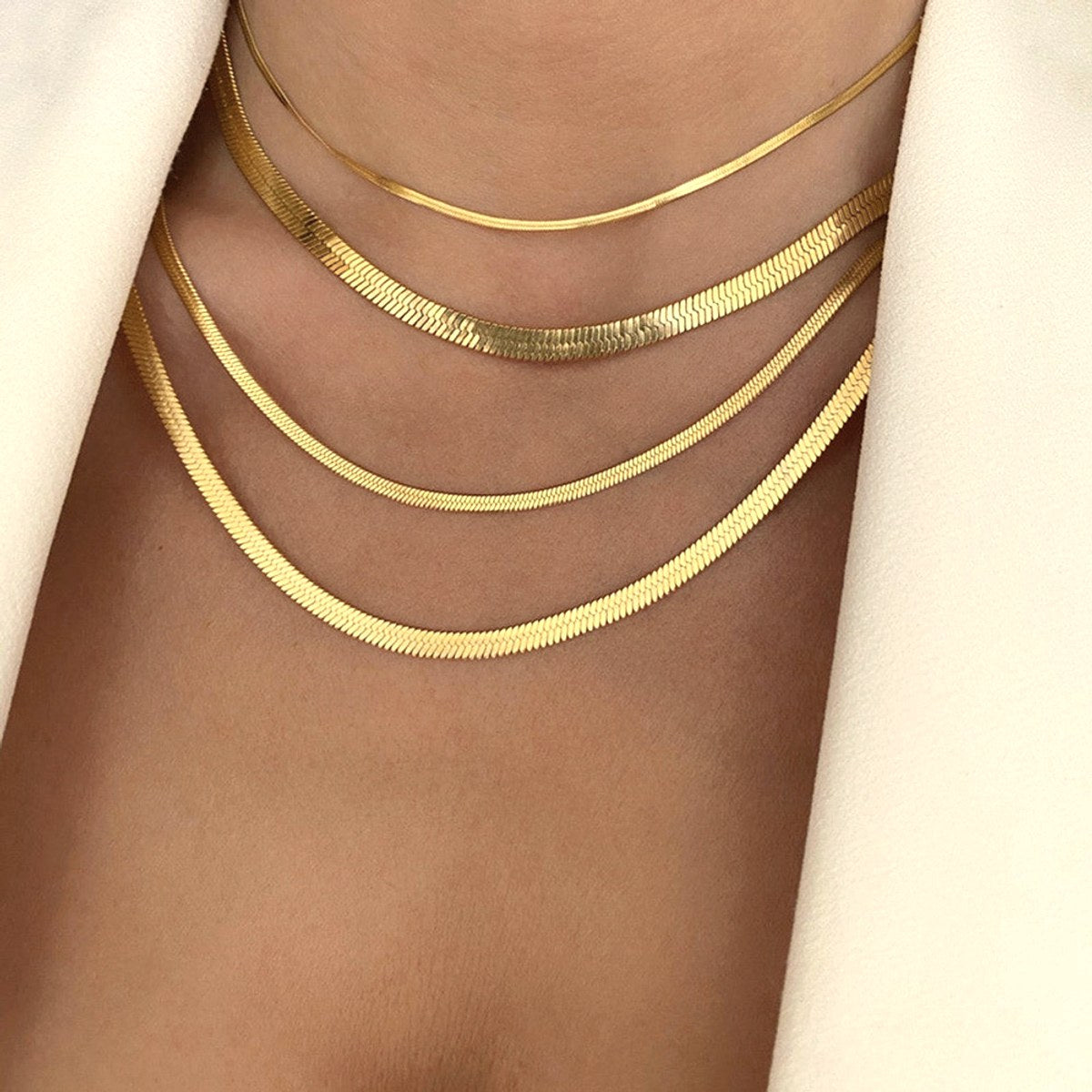 Voie herringbone ketting gelaagd op de huid
